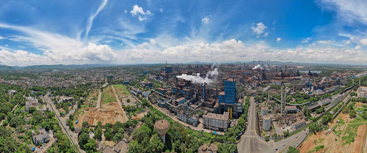 An industrial area with factories, smokestacks, and a mix of urban and green spaces.