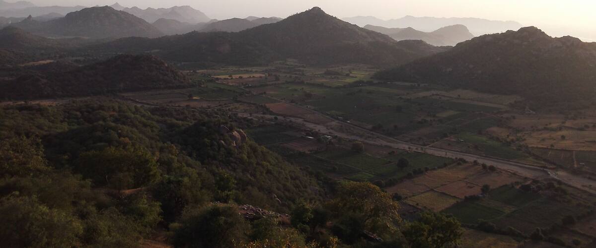 A mountainous landscape with rolling hills and a winding road.