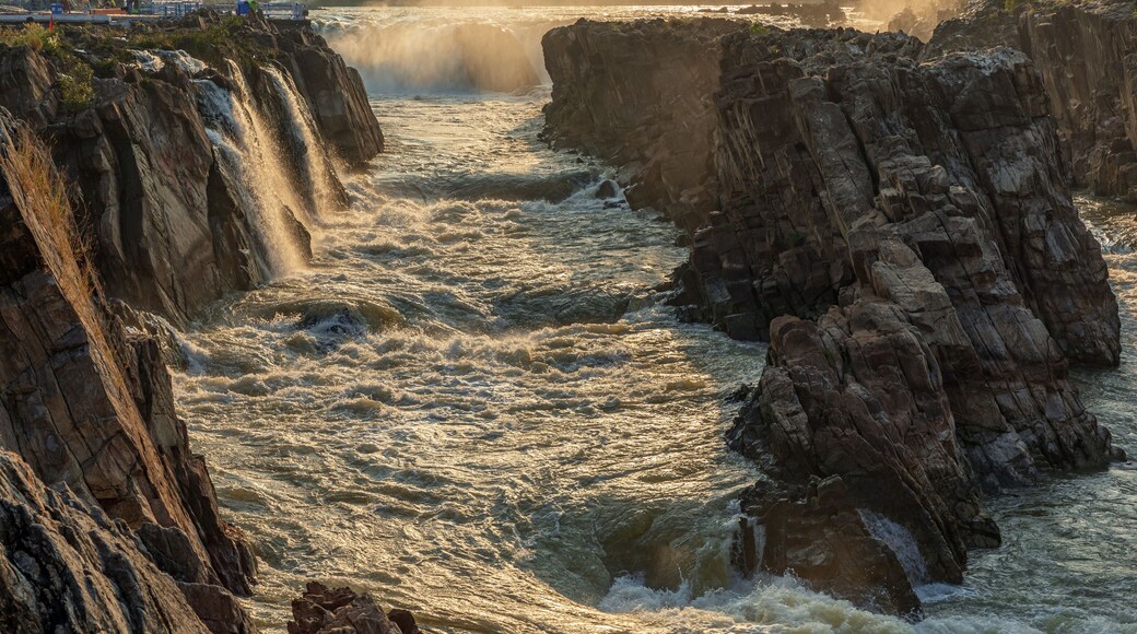 A turbulent river flowing through a rocky gorge with sunlight reflecting off the water.