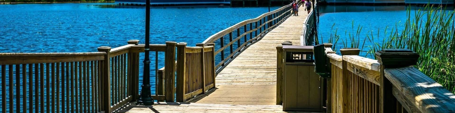 A wooden pier extending over a body of water, leading to a building with a sign that reads "RAN JIM'S".
