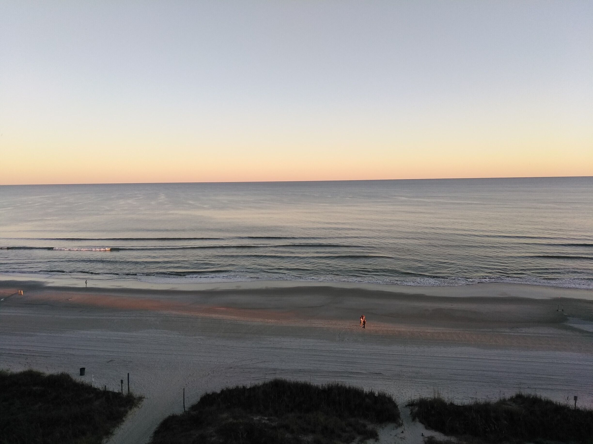 A beautiful sunset over a lake-like calm Atlantic Ocean.