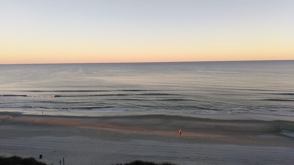 A beautiful sunset over a lake-like calm Atlantic Ocean.