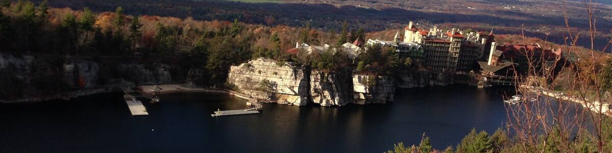 A lake surrounded by rocky cliffs and autumn-colored trees.