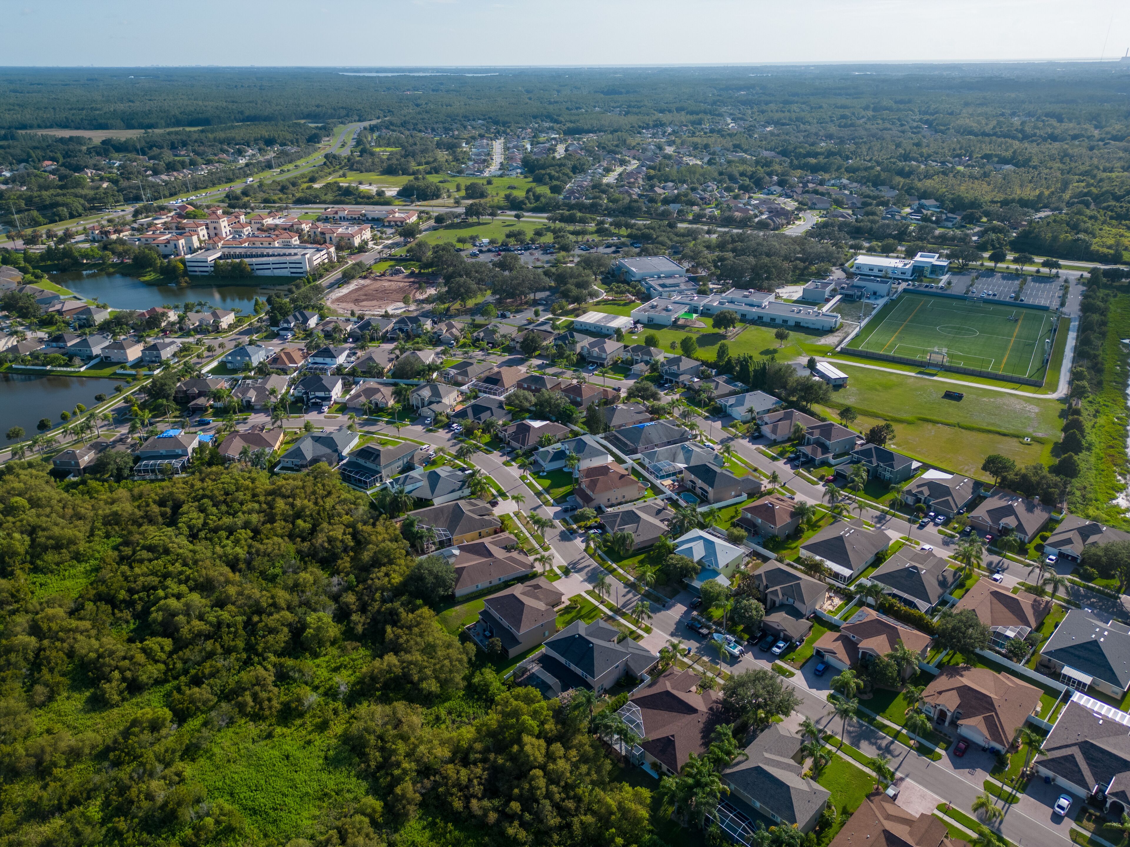 Drone shot of suburban neighborhood in New Port Richey Florida with houses and homes in sunny day