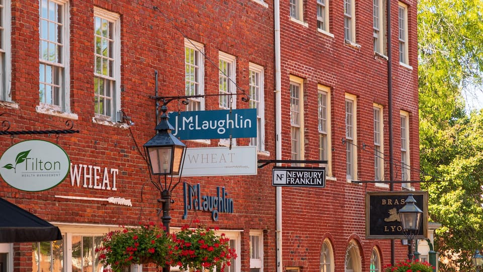 A red brick building with multiple signs, including 'J. McLaughlin' and 'Wheat'.