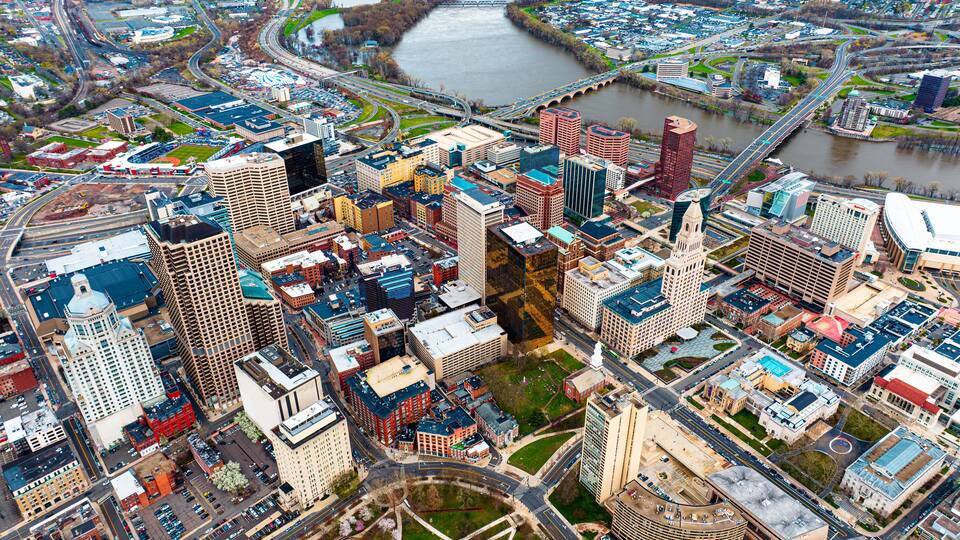 A cityscape with a river, bridges, and a mix of modern and historic buildings.