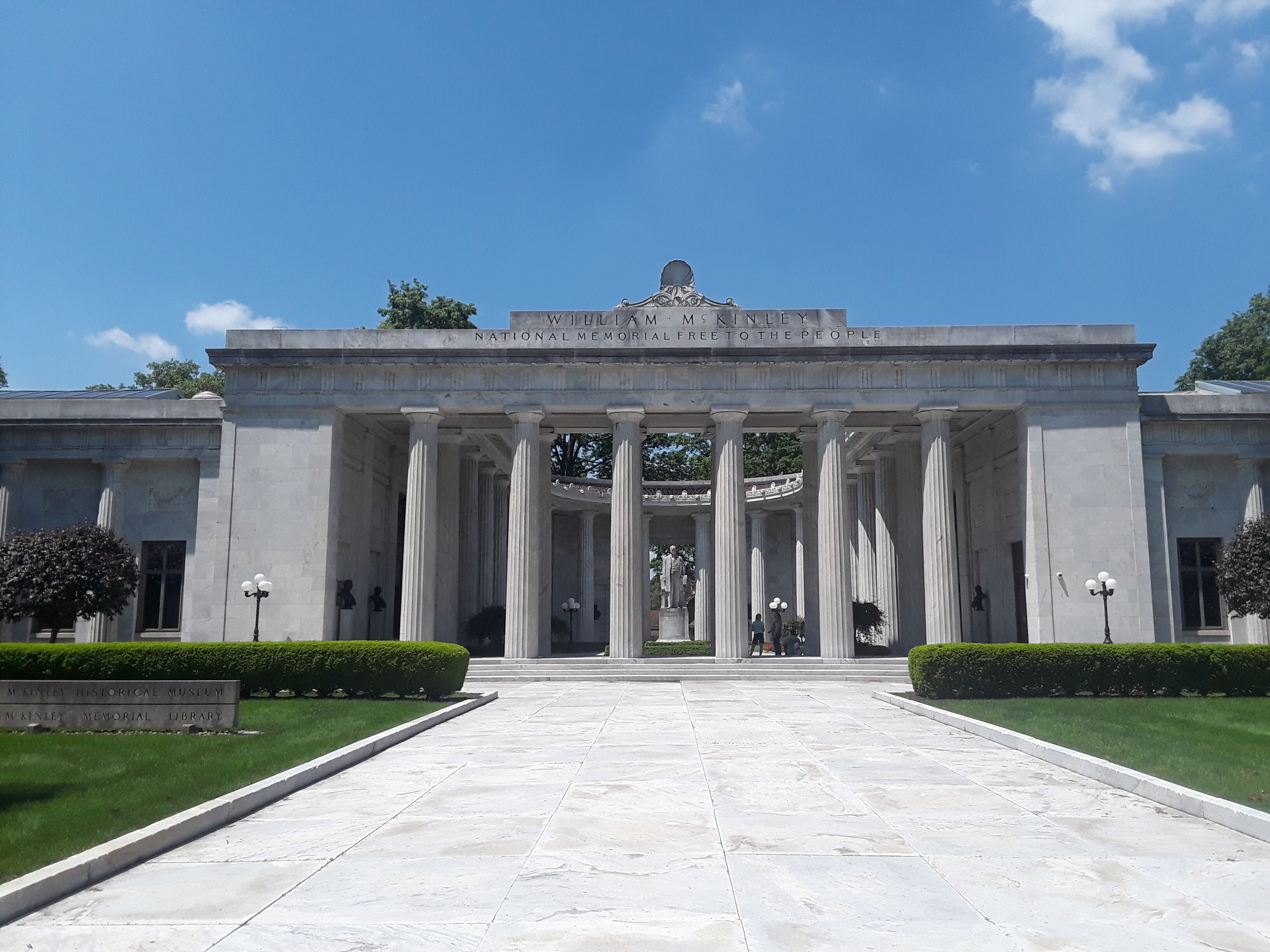 The entrance to the McKinley Memorial Library, featuring classical architecture with columns and a clear blue sky.