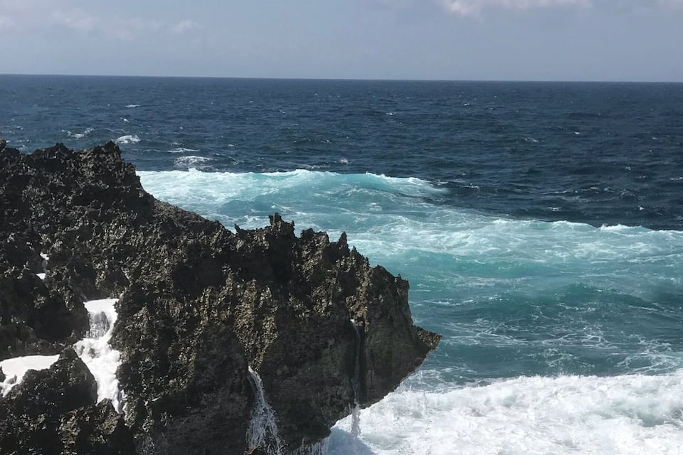 A rocky coastline with waves crashing against the rocks.