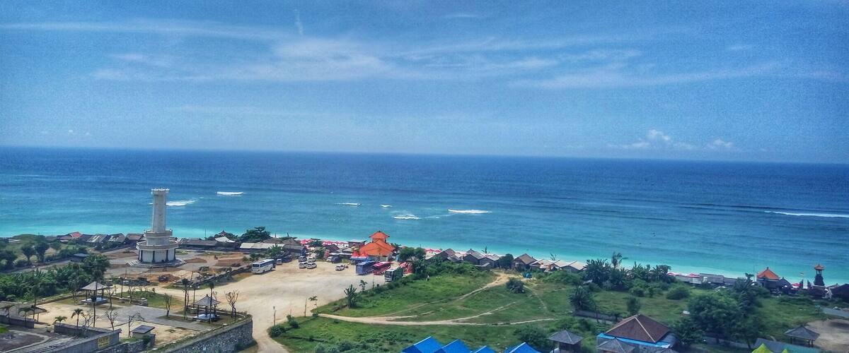 A coastal town with a lighthouse, beach, and traditional houses.