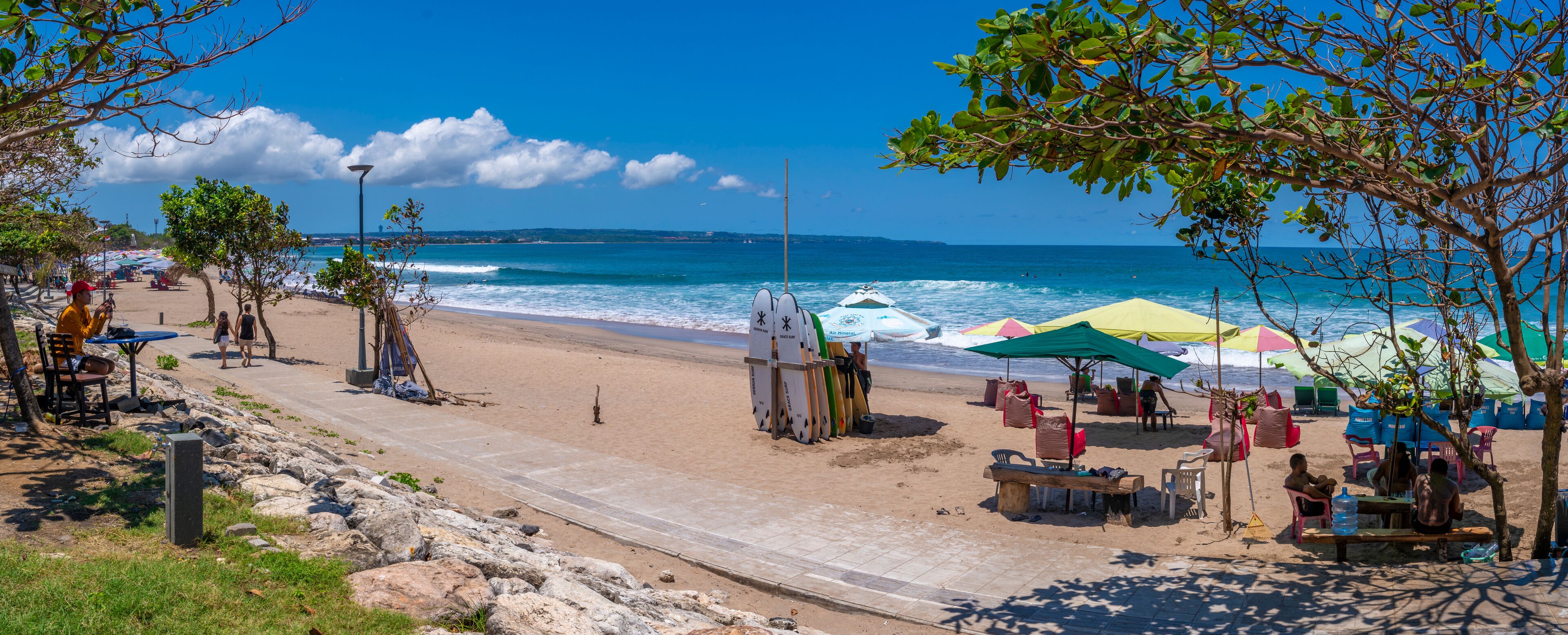 View of vendors and surf boards on sunny morning on Kuta Beach, Kuta, Bali