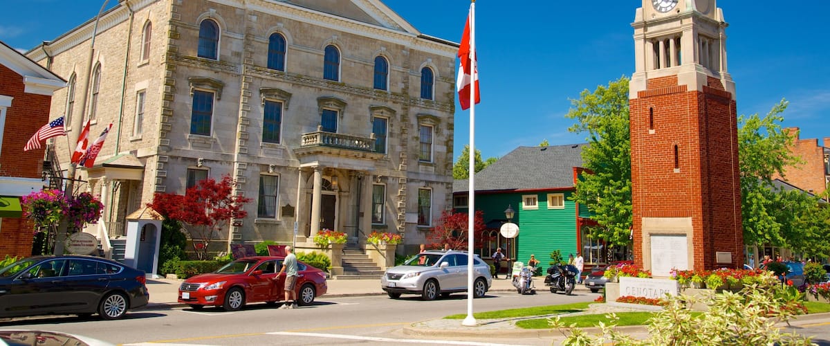 A historic building with a clock tower, surrounded by cars and pedestrians.