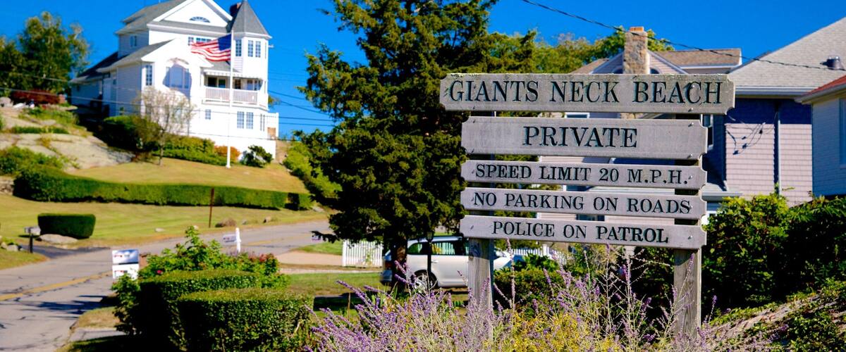 A sign indicating Giants Neck Beach is private with a speed limit of 20 mph and no parking on roads.