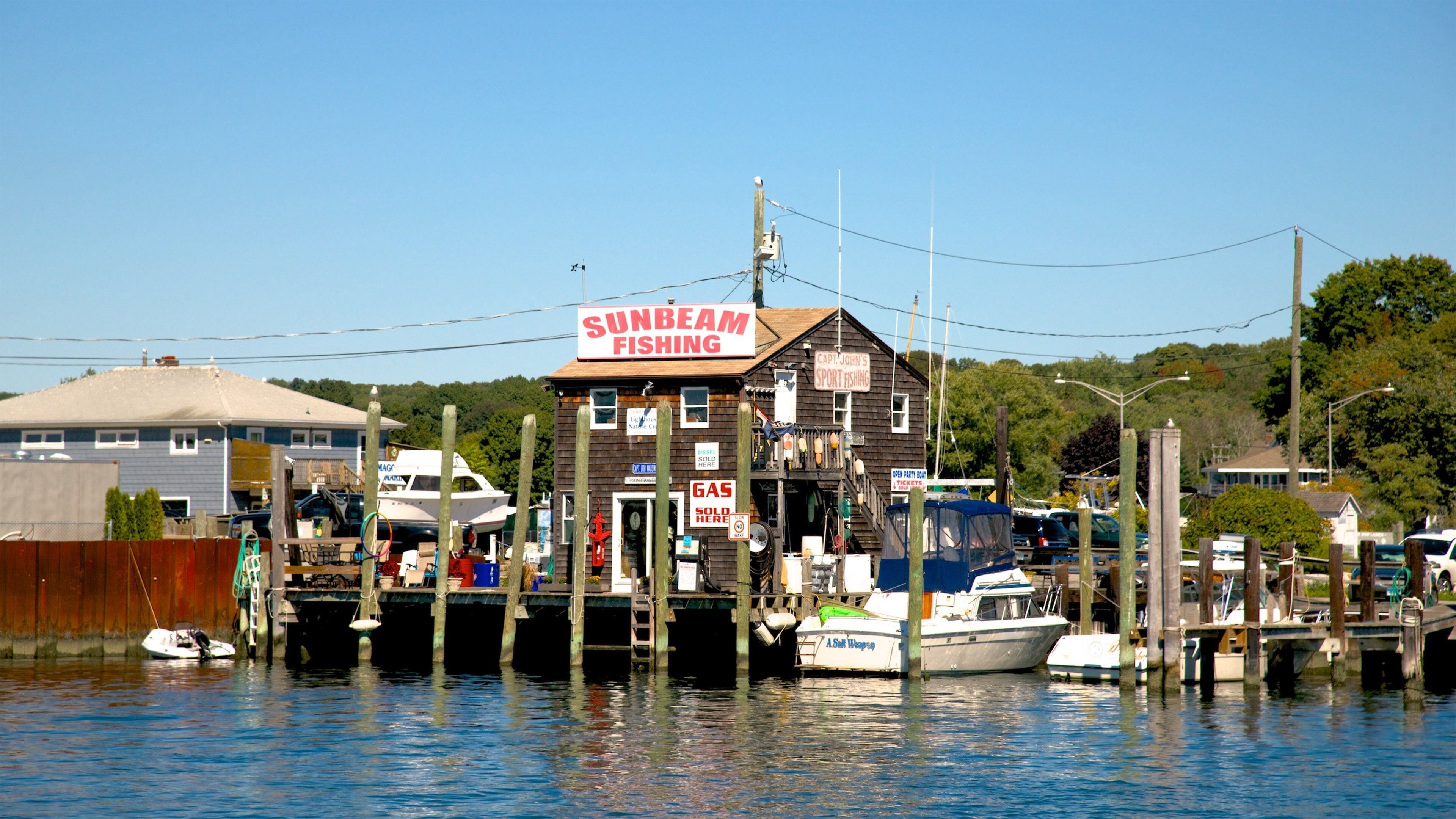 A waterfront with a docked boat, a building labeled 'Sunbeam Fishing', and a sign for 'Capt. John's Sport Fishing'.