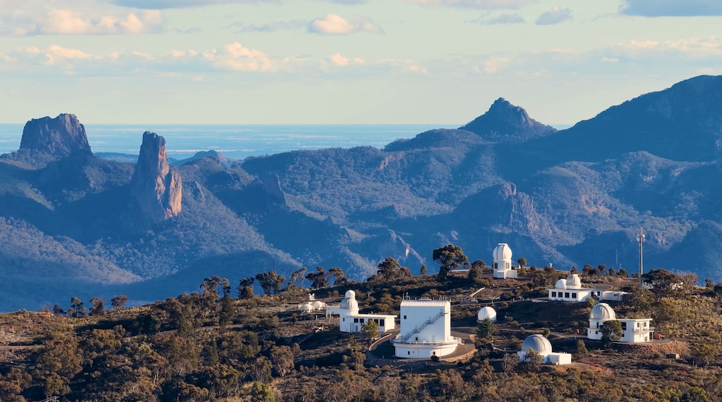 A mountainous landscape with several white observatory domes and a clear view of the ocean.