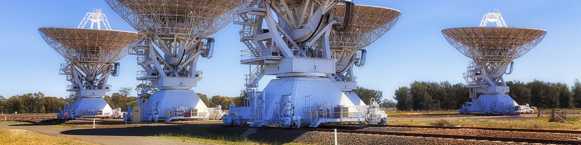 Large radio telescopes in a rural setting.