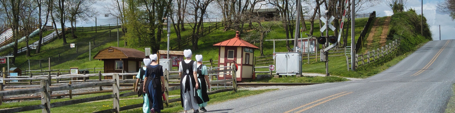 Teenage Amish Boys and Girls Walking Along a Rural Road in the Countryside on a Spring Day