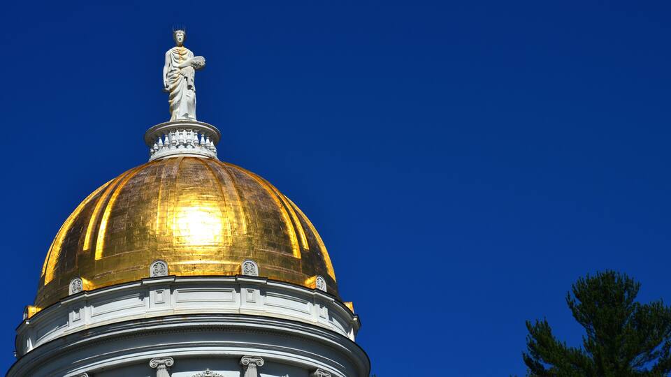 A golden dome with a statue on top.