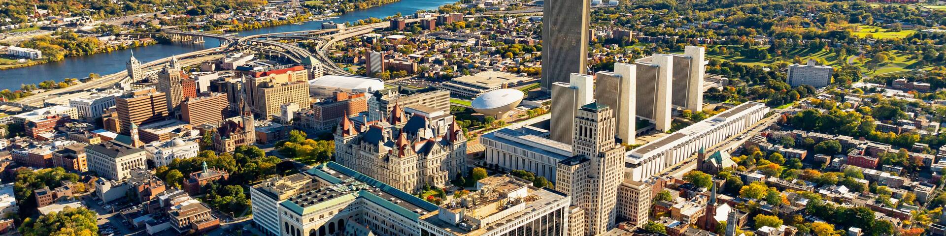 Albany cityscape and river view. A stunning aerial perspective of Albany, USA reveals the vibrant cityscape, river, and surrounding greenery on a clear day.