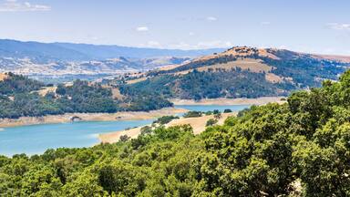 High angle view of Anderson Reservoir, a man made lake in Morgan Hill, managed by the Santa Clara Valley Water District, maintained at low level due to failure risk in case of earthquake; California