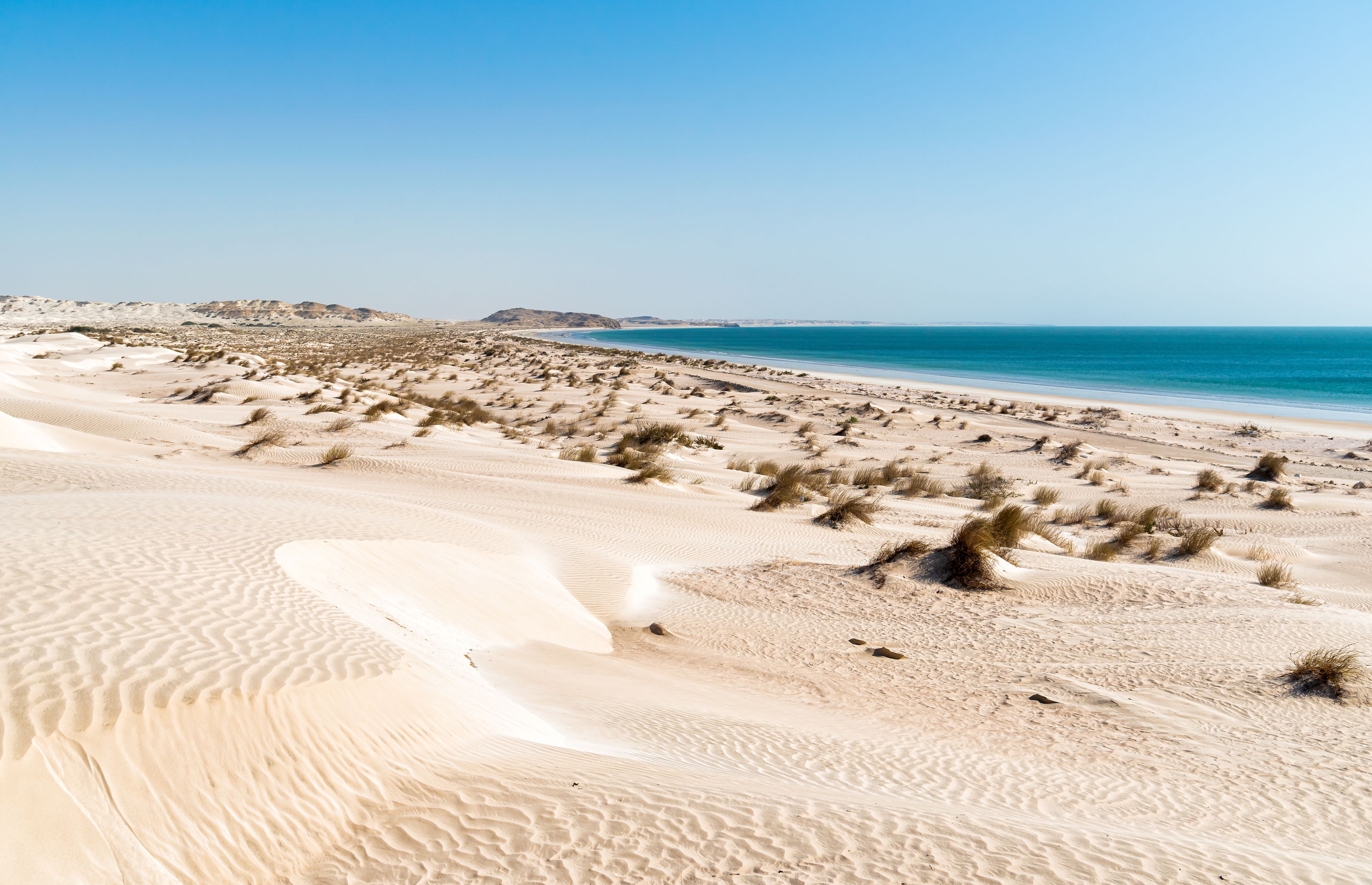 Landscape of Al Khaluf beach with dunes and white sands in the Arabian Sea of Oman.