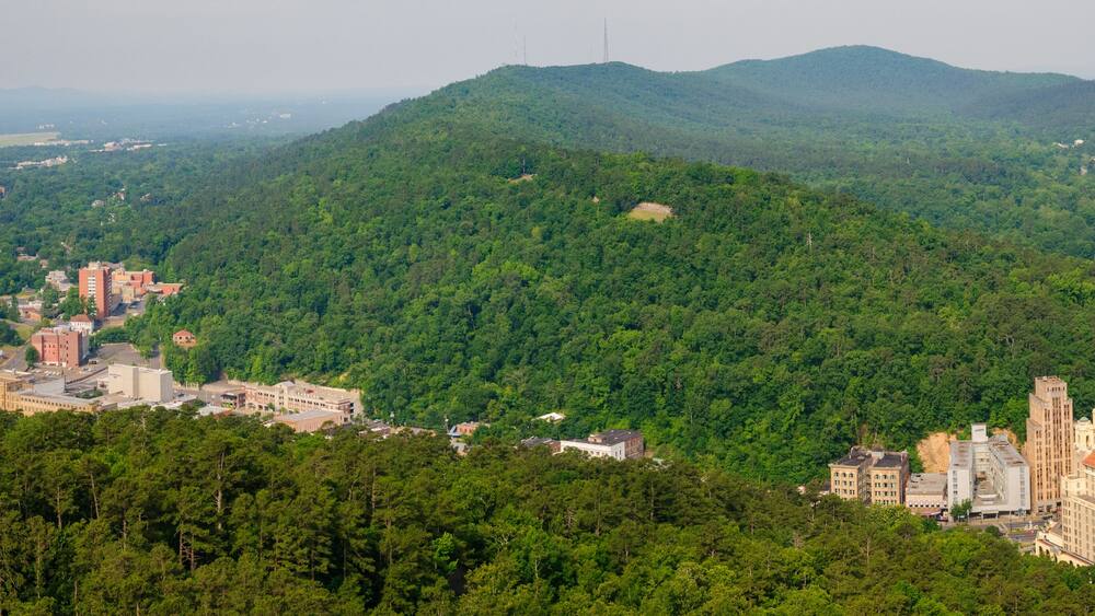 A town nestled in a valley with a prominent hill in the background.