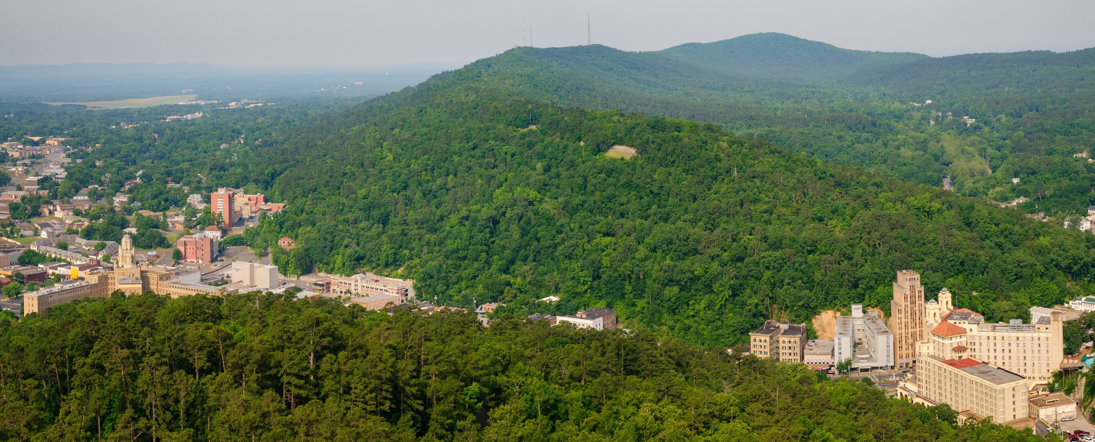 A town nestled in a valley with a prominent hill in the background.