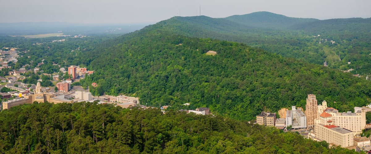 A town nestled in a valley with a prominent hill in the background.