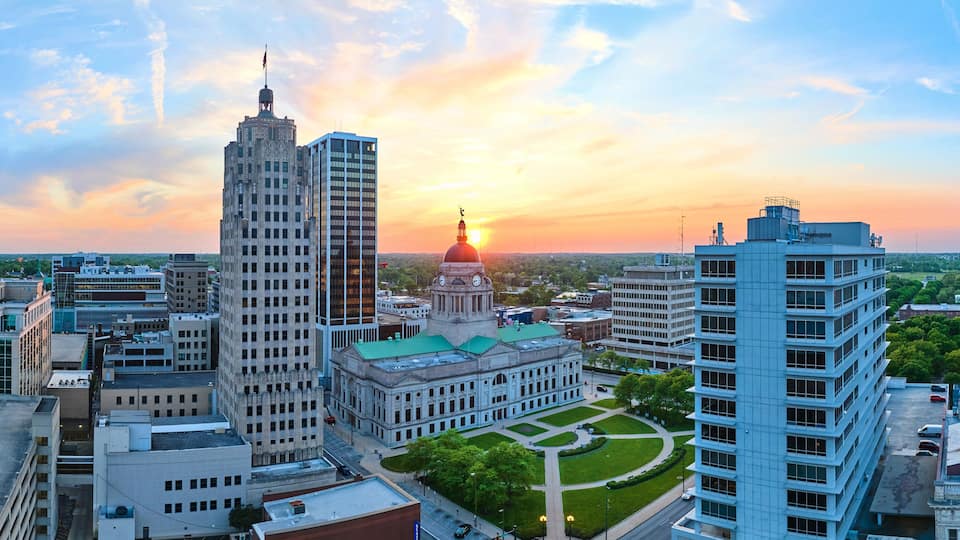 Panorama aerial downtown Fort Wayne golden morning sunrise breaking into brilliant blue skies