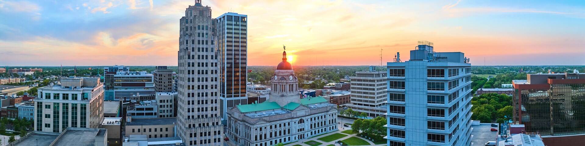 Panorama aerial downtown Fort Wayne golden morning sunrise breaking into brilliant blue skies