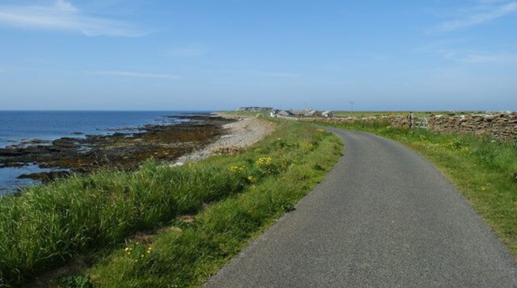 Road alongside Bay of Sandquoy Road runs alongside the eastern shore of the Bay of Sandquoy , only just above the high tide level on the island of Sanday.