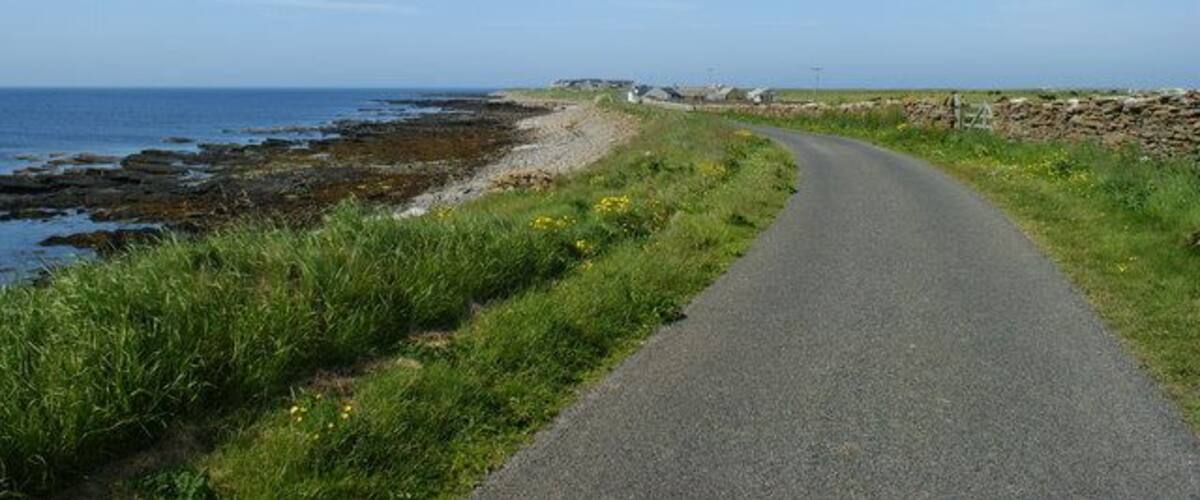 Road alongside Bay of Sandquoy Road runs alongside the eastern shore of the Bay of Sandquoy , only just above the high tide level on the island of Sanday.