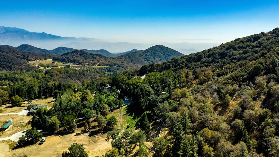Aerial, drone view of Oak Glen located between the San Bernardino Mountains and Little San Bernardino Mountains with several apple orchards before the Fall color change