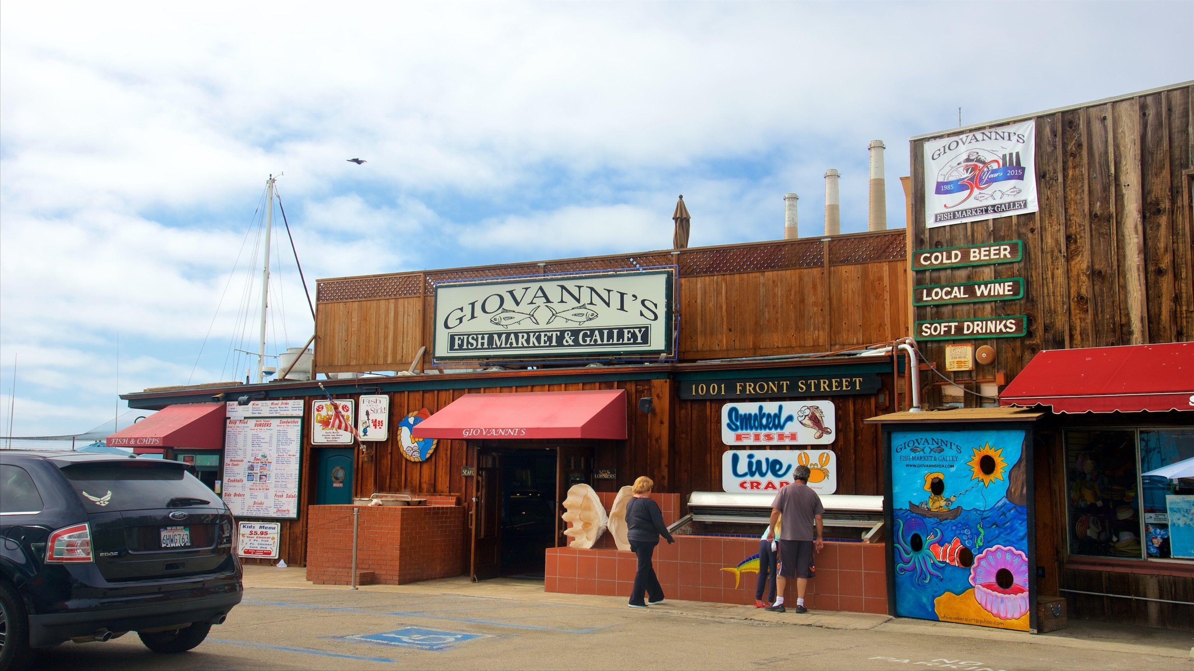 Morro Bay showing shopping as well as a family