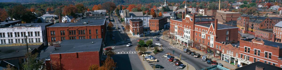 This is a panorama view from the Bell Tower in Claremont. It shows a typical scene from small town America. The buildings are mostly made from red brick. We see fall foliage in the background.