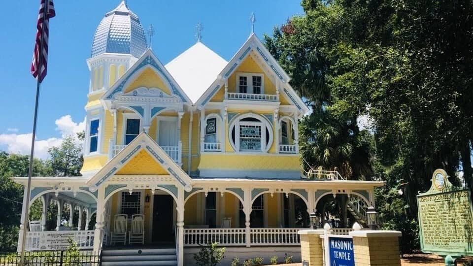 A yellow and white building with a dome and a sign that reads "Masonic Temple".