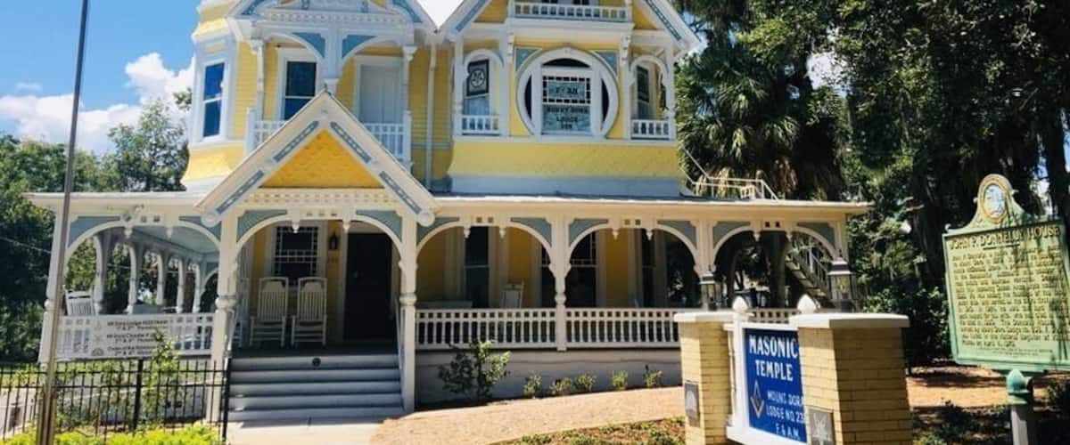 AKA The Donnelly House
John P. Donnelly came to Mount Dora in 1879 from Pittsburgh, PA. He married Annie McDonald Stone in 1881 and built this Queen Anne style house in 1893 as a gift to her. He was among the founders of the local yacht club, and served as the city´s first mayor in 1910. The Donnelly House, now owned by Mount Dora Lodge #238, F&AM, was listed in the National Register of Historic Places on April 4, 1975.
Mount Dora is a cute town on the banks of Lake Dora surrounded by antiquing opportunities and is just a short drive to the massive Renningers Antique Market