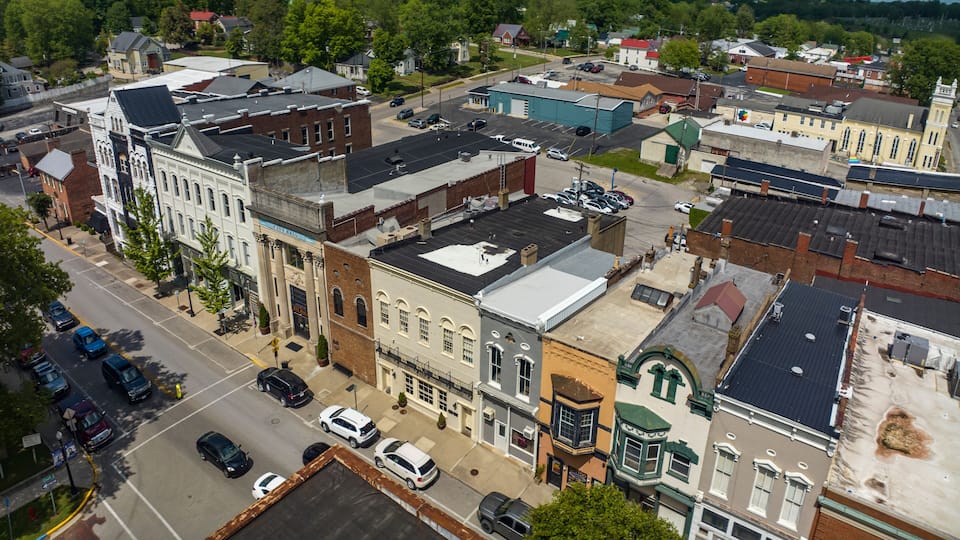 A downtown area with historic buildings, a parking lot, and a street.
