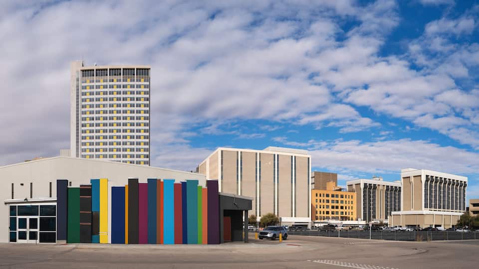 Panoramic Modern Midland Texas city skyline and downtown skyscrapers, dramatic cloudscape with American and Texas Flags waving in the wind