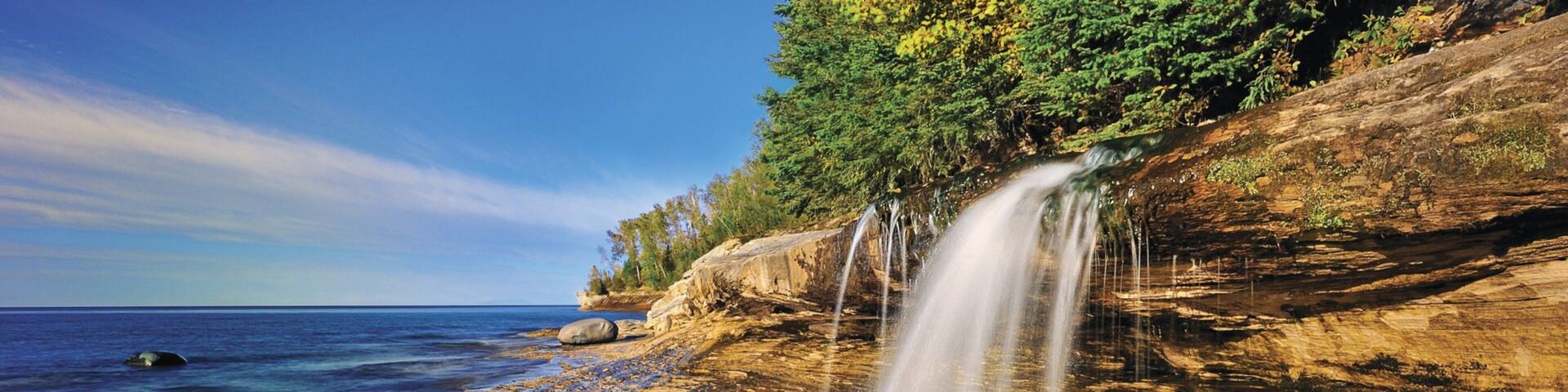 Munising showing a waterfall and rugged coastline