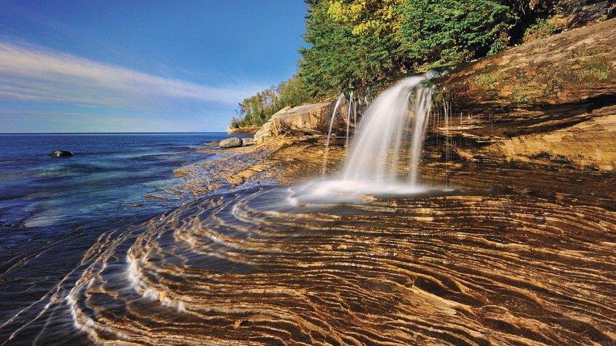 Munising showing a waterfall and rugged coastline