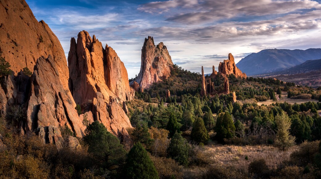 Picturesque scene within the Garden of the Gods national park in Colorado Springs, Colorado. There are jagged red sandstone rocks erupting from the ground reaching for the sky.