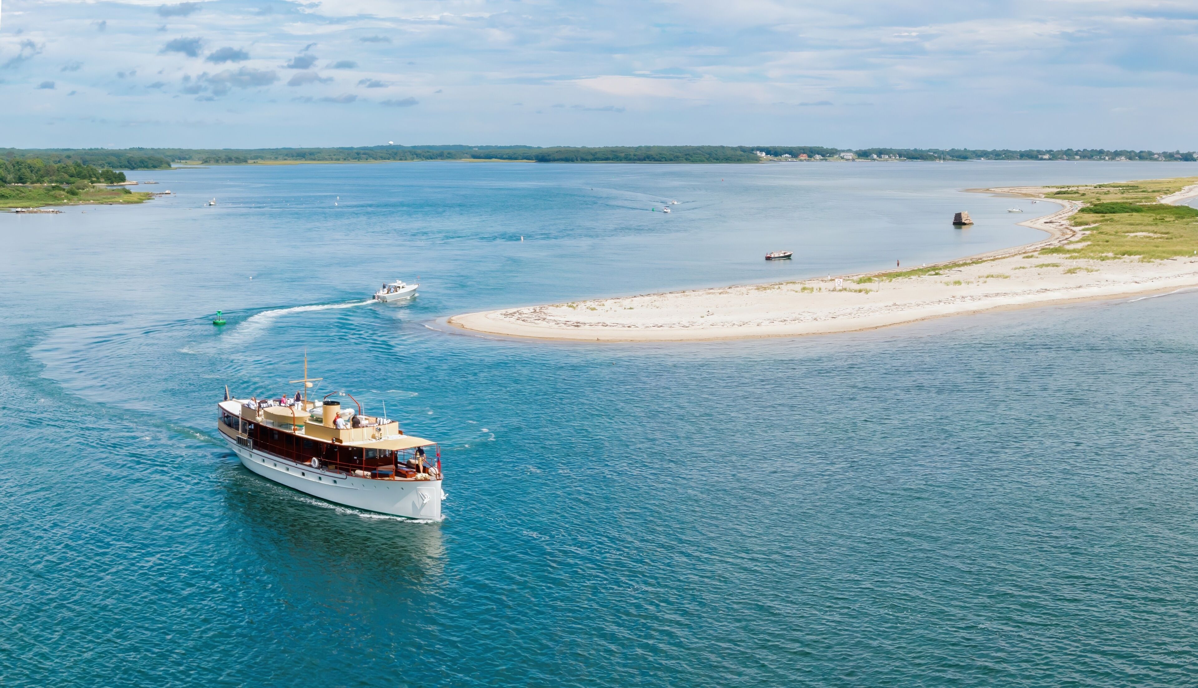 Antique boat sailing around Sandy Point, a sandspit harbor in Stonington, Connecticut, United States.