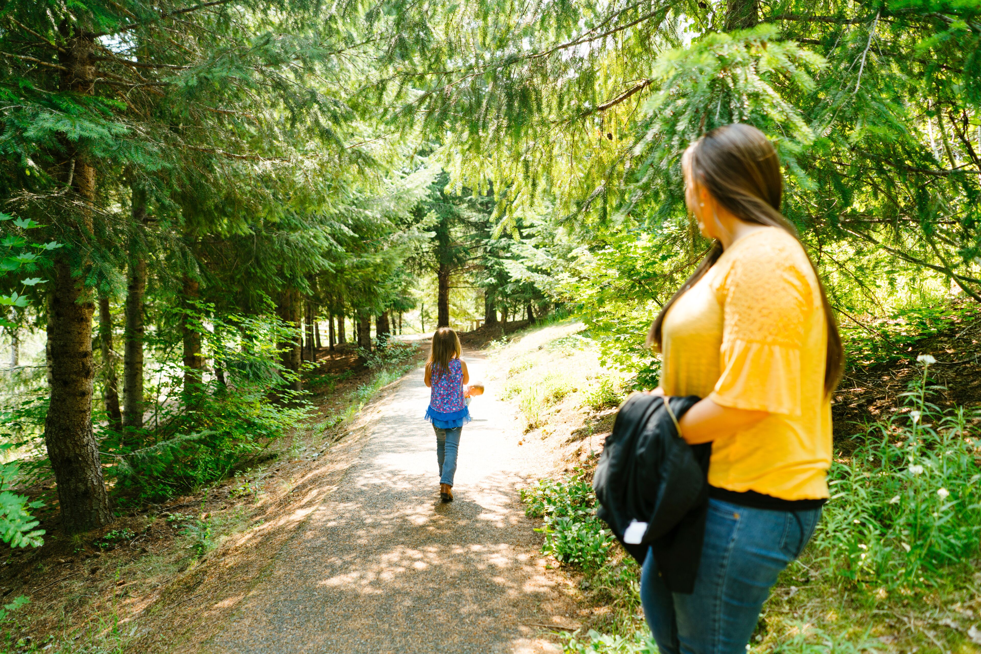 Rear view of a mother and daughter hiking on a trail