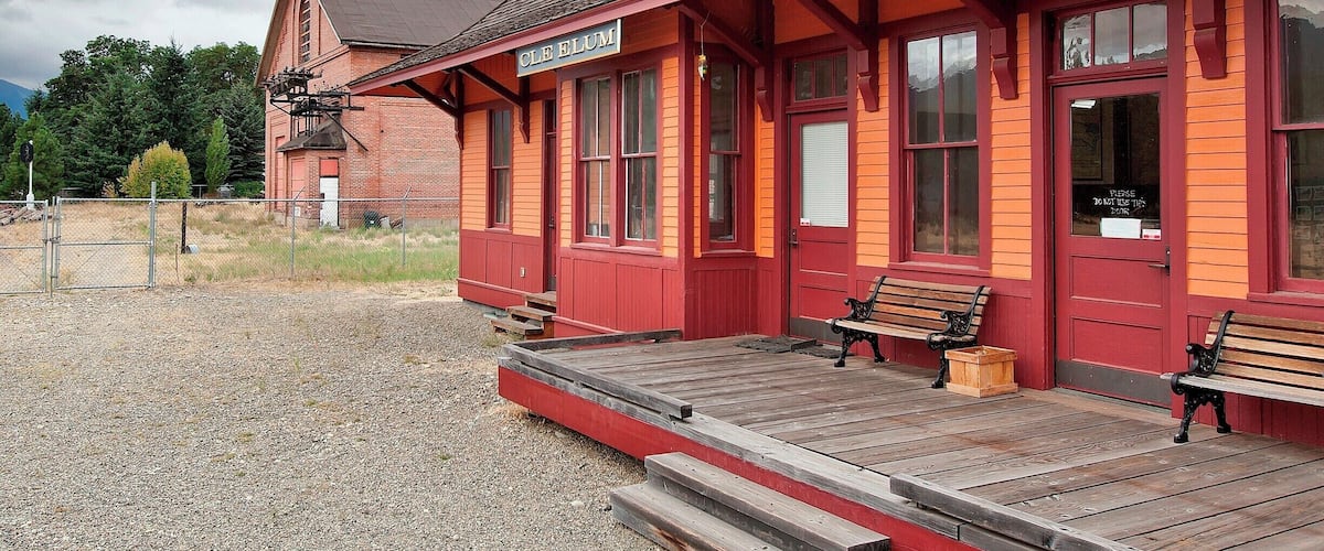 This train depot was built in 1909 as part of a railway expansion into the Pacific Northwest. Depots and rail yards were built 100 to 150 miles apart (240km) as crew rest stops and an engine service stations. Originally this yard consisted of the depot, roundhouse, turntable, ash tank, water tank and bunkhouse. When the line was electrified in 1920 the substation (seen in the background) was added.
By 1980 The Milwaukee Road was near bankruptcy. They sold off most of their property and transferred the line itself to the state. Today, a 100 mile stretch of that line forms the John Wayne Pioneer Trail, a non-motorized trail open to the public, including a 2.3 mile long (3.7km) tunnel under Snoqualmie Pass (remember to bring your flashlight).