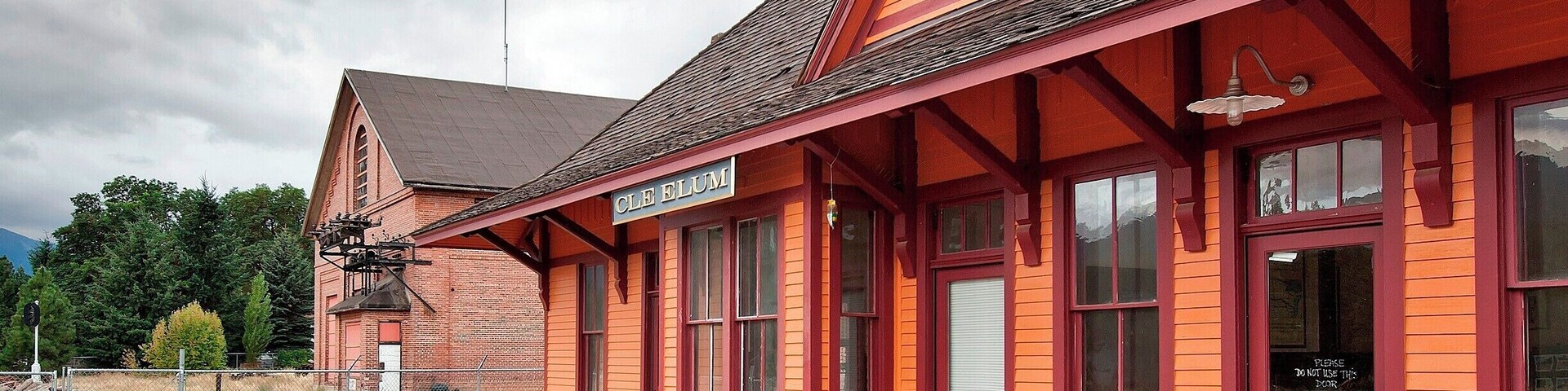 This train depot was built in 1909 as part of a railway expansion into the Pacific Northwest. Depots and rail yards were built 100 to 150 miles apart (240km) as crew rest stops and an engine service stations. Originally this yard consisted of the depot, roundhouse, turntable, ash tank, water tank and bunkhouse. When the line was electrified in 1920 the substation (seen in the background) was added.
By 1980 The Milwaukee Road was near bankruptcy. They sold off most of their property and transferred the line itself to the state. Today, a 100 mile stretch of that line forms the John Wayne Pioneer Trail, a non-motorized trail open to the public, including a 2.3 mile long (3.7km) tunnel under Snoqualmie Pass (remember to bring your flashlight).