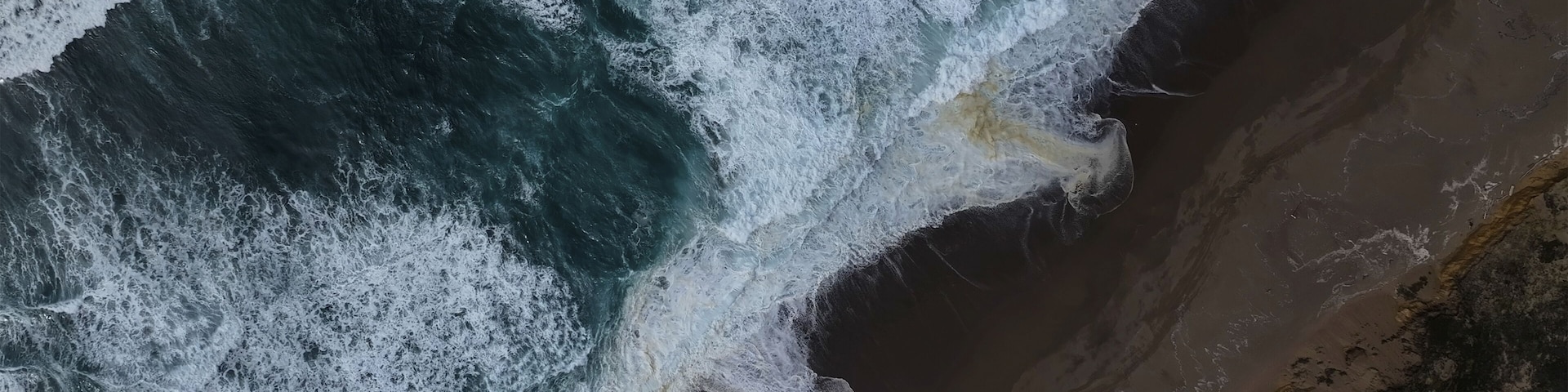 Un paisaje costero con olas rompiendo sobre la orilla.