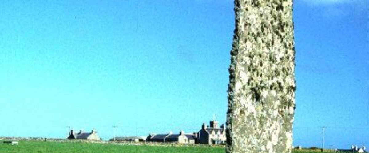 Holland House standing stone. North Ronaldsay. Standing stone 13' high by 4'wide and only 4" thick at the base. At a height of 6' there is a small hole through which you can peep if you are tall enough. In 1794 it was recorded that 50 inhabitants danced round it by moonlight on the first day of the year!