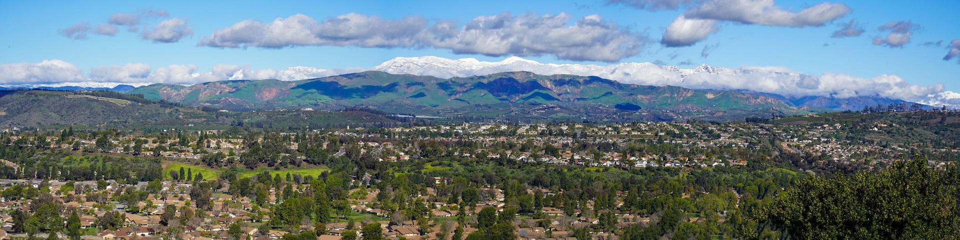 Panoramic view of snow mountains and citrus trees and Santa Rosa Valley and homes Ventura California during winter snow storms