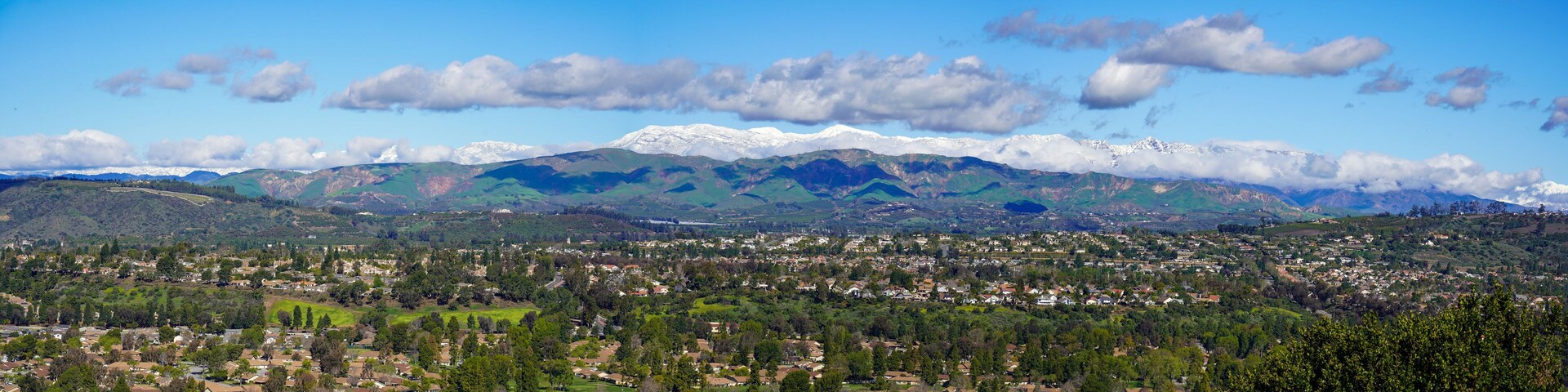 Panoramic view of snow mountains and citrus trees and Santa Rosa Valley and homes Ventura California during winter snow storms