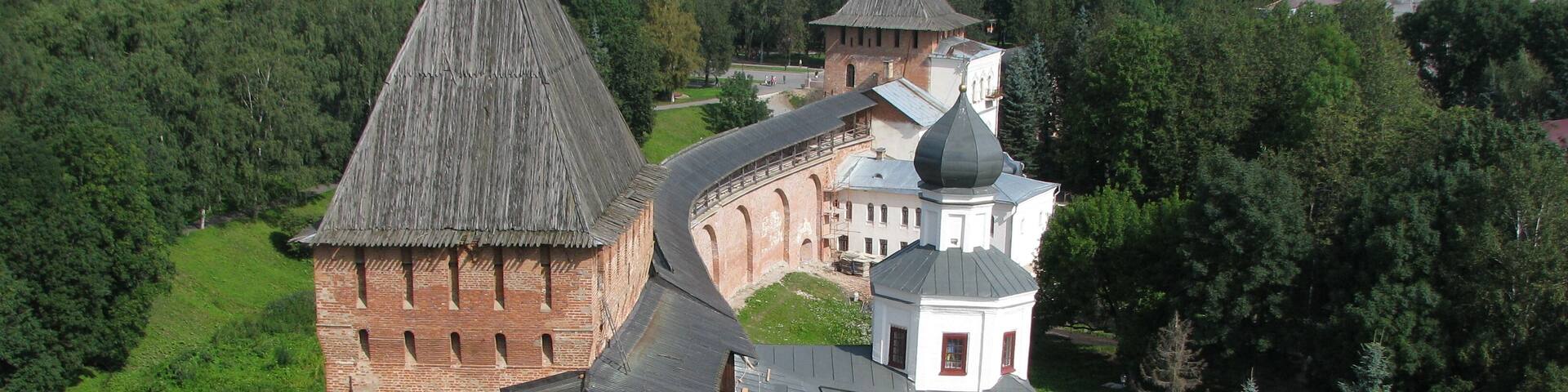 A historic castle with a prominent tower and a smaller adjacent building with a dome.